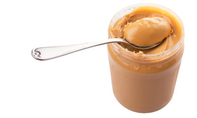 An opened jar of peanut butter with a small spoon
