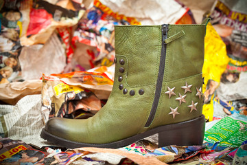 Women's green leather boots crumpled sheets of colored paper.