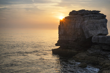 Beautiful rocky cliff landscape with sunset over ocean