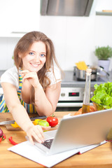 Obraz na płótnie Canvas Frau mit Laptop in der Küche 