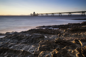 Long exposure landscape image of pier at sunset in Summer