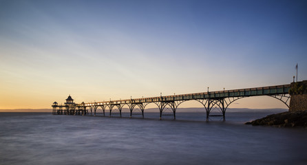 Beautiful long exposure sunset over ocean with pier silhouette