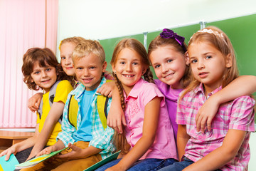 Group of children stand close to each other hug