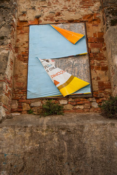 Vecchi poster pubblicitari strappati affissi su muro
