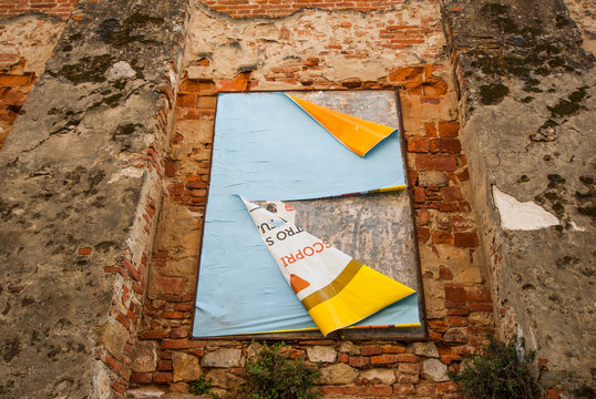 Vecchi poster pubblicitari strappati affissi su muro