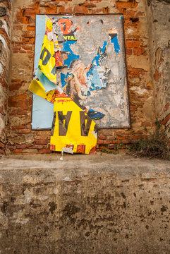 Vecchi poster pubblicitari strappati affissi su muro