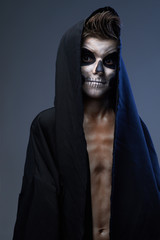 teenager with make-up of the skull in black cape