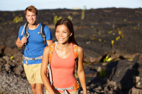 Hiking people - couple walking on lava field