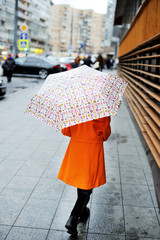 Colorful kid girl with umbrella on city street