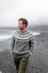 Man walking on black sand beach on Iceland