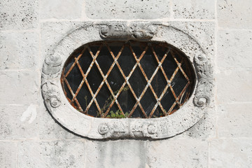 Old oval small window with bars close-up