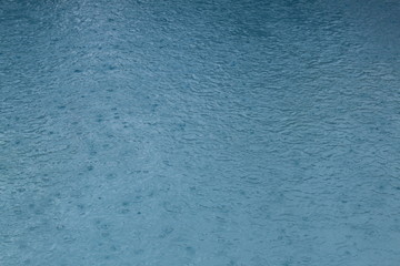 Regentropfen fallen in Swimmingpool