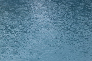Regentropfen fallen in Swimmingpool