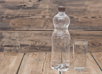 Water bottle with glass on wooden table