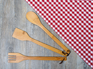 wooden cutlery on a napkin with red and white tiles
