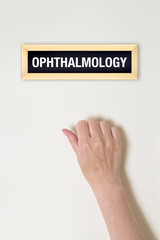Female hand is knocking on Ophthalmology door