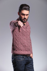 Serious young fashion man showing the thumb down gesture