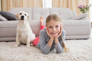 Cute little girl with her puppy on rug