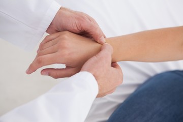 Doctor examining patients wrist