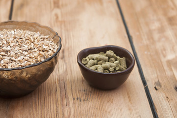 beer ingredients, hops and malt on wooden table top