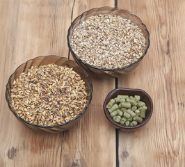 beer ingredients, hops and malt on wooden table top