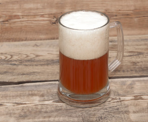 Mug of beer close up on wooden table