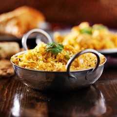 indian chicken biryana in balti dish with naan and samosa