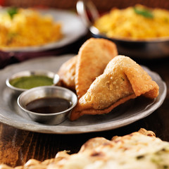 two indian samosa with mint and hot chutney
