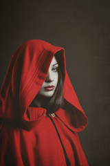 Naklejka premium Studio portrait of mysterious woman hooded in red