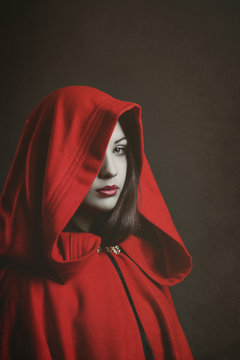 Studio portrait of mysterious woman hooded in red Photos | Adobe Stock