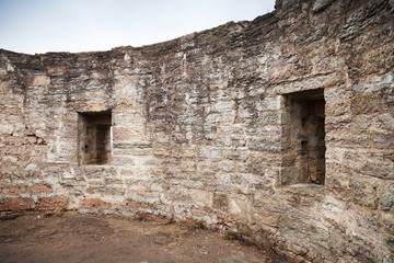 Round ruined interior with empty windows of old stone fort tower