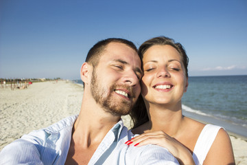 Happy couple taking a photo on a beach