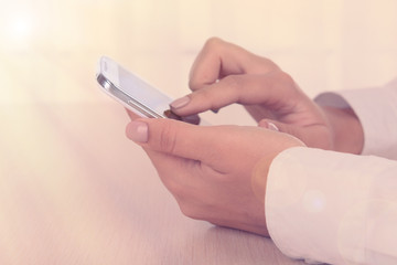 Woman using smartphone on light background