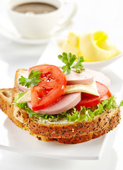 breakfast sandwich with sliced sausage and tomato