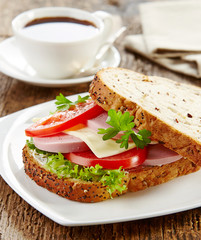 breakfast sandwich with sliced sausage and tomato