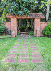 Walkway to brick doorway in green garden