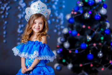 little girl in suit Snow Maiden near the Christmas tree