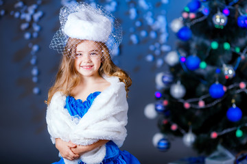 little girl in suit Snow Maiden near the Christmas tree