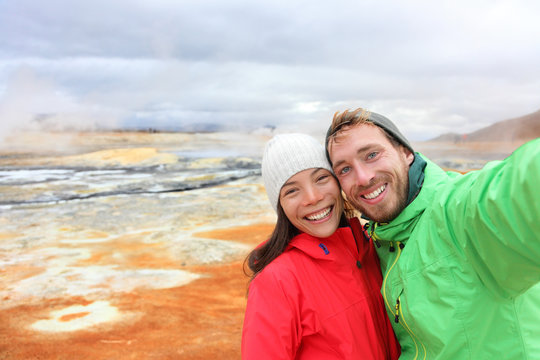 Iceland tourists selfie at mudpot hot spring