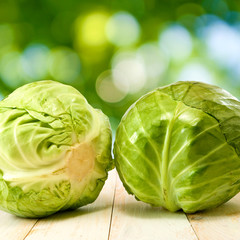 cabbage on wooden table on green background