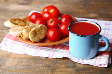 Homemade tomato juice in color mug, toasts and fresh tomatoes