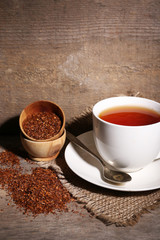 Cup of tasty rooibos tea, on wooden table