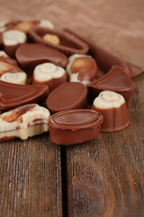 Different kinds of chocolates on wooden table close-up