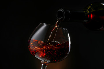 Red wine pouring into wine glass, close-up