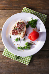 Sandwich with salami on napkin on wooden background