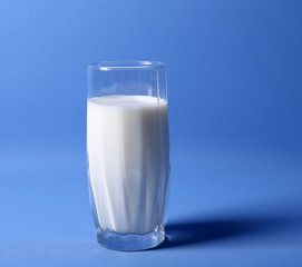 Milk in glass on blue background