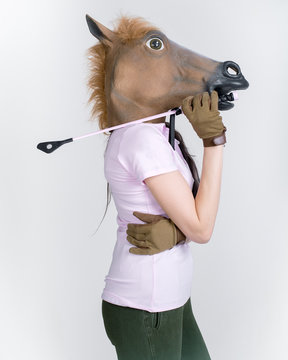 Portrait of a young woman wearing a horse mask