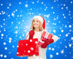 smiling young woman in santa helper hat with gifts