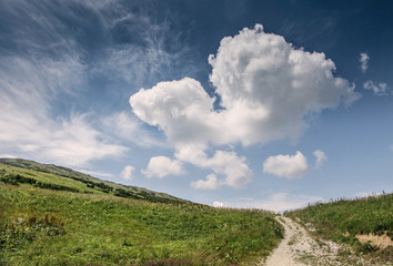 Hill landscape with deep blue sky and big cloud