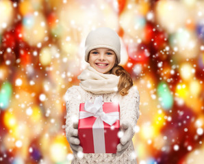 girl in hat, muffler and gloves with gift box